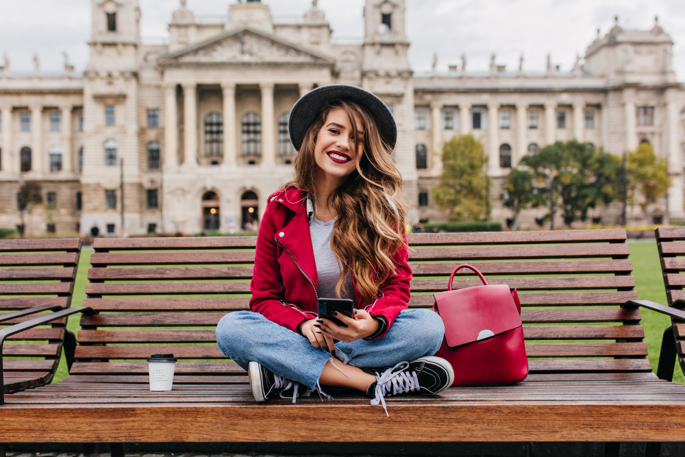 spectacular lady with trendy hairstyle sitting steps front old historical building